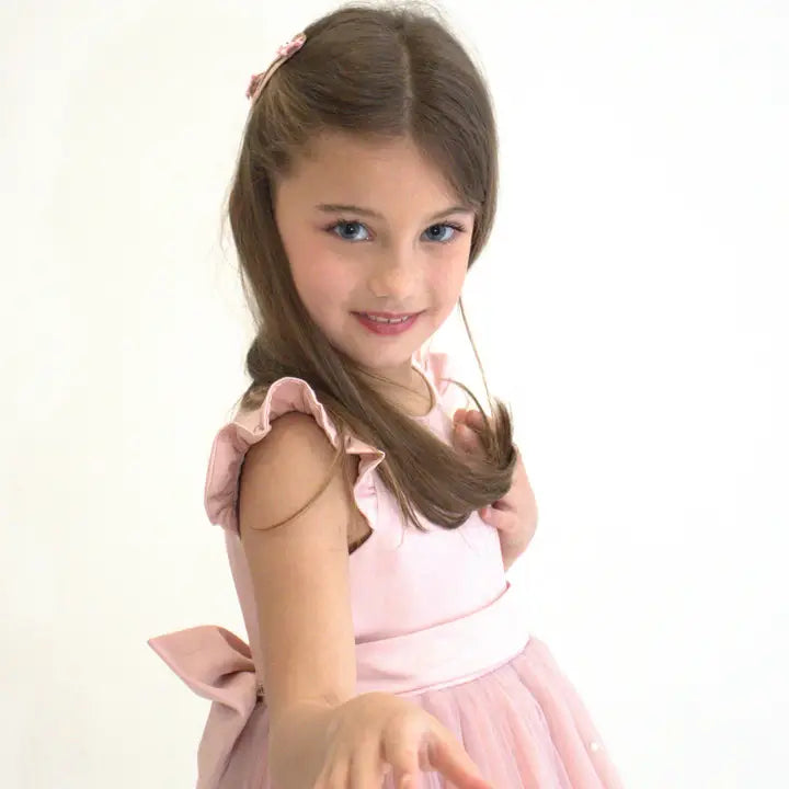 Girl with long hair wearing glitter ballet shoe hair clips on a white background