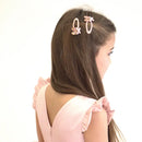 Girl with long hair wearing glitter ballet shoe hair clips on a white background