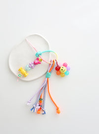 Colorful beaded keychain with smiley face charm on a white background