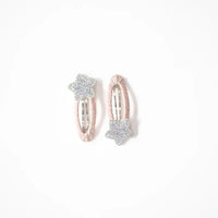 Photo of two kids’ hair clips with silver glitter star accents attached to soft blush-pink oval bases, displayed on a white card with a small gold heart.