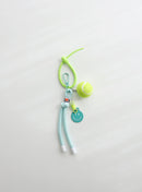 A bright green tennis ball keychain featuring a mini tennis ball charm, a mint smiley face tag, and an adjustable loop strap for easy attachment, displayed on a clean white background.
