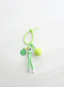 A bright green tennis ball keychain featuring a mini tennis ball charm, a green smiley face tag, and an adjustable loop strap for easy attachment, displayed on a clean white background.