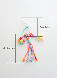 Colorful bag charms with beads and a smiley flower placed on a white background with measurement which is 5inches of the top holder part and 6.1inches of the body of bag charm