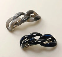 Navy and grey hair clips with a chain-link design on a white background