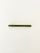 One slim rectangular hair clip in marbled shades of dark green, neatly displayed on a white surface.