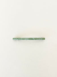 One slim rectangular hair clip in marbled shades of jade neatly displayed on a white surface.