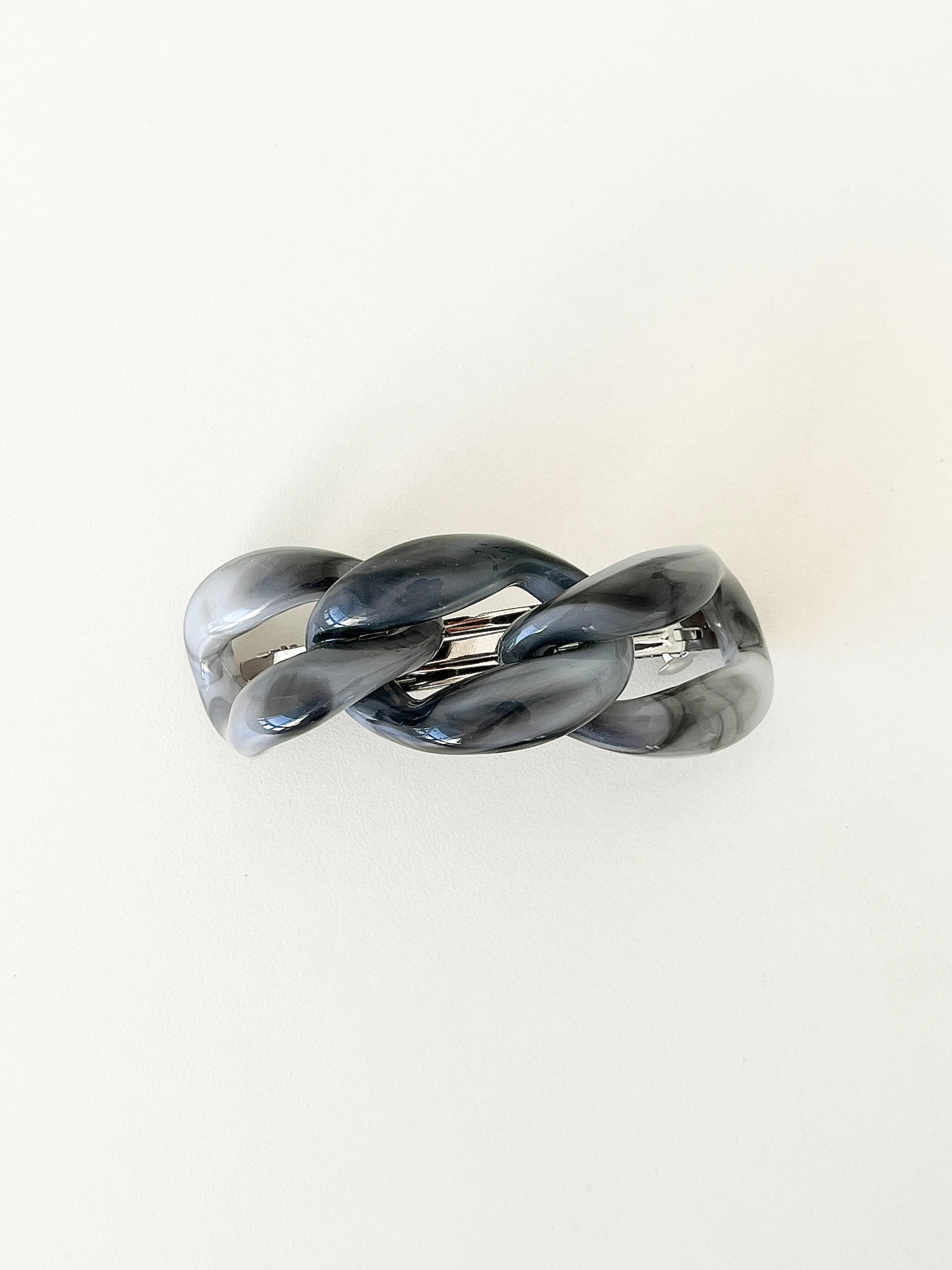 Gray marbled hair clip on a white background.