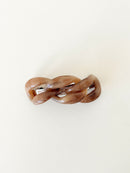 Brown hair clip with a chain-link design on a white background