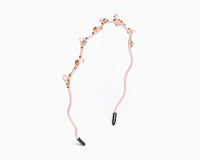 a hairband with branch-like design and small crystal in light pink color.